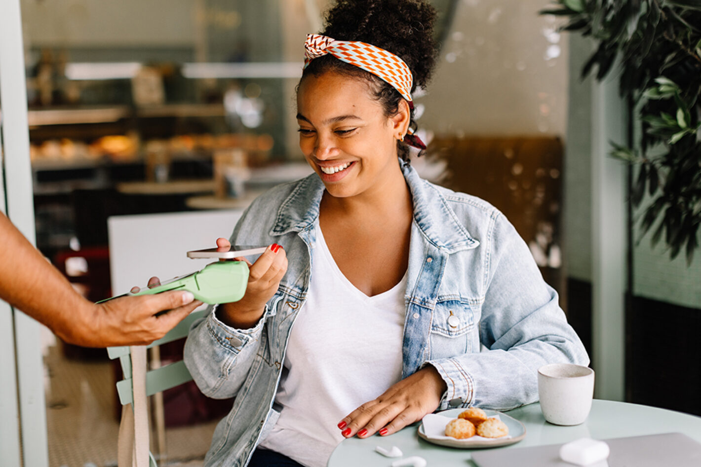 Female making contactless payment at coffee shop
