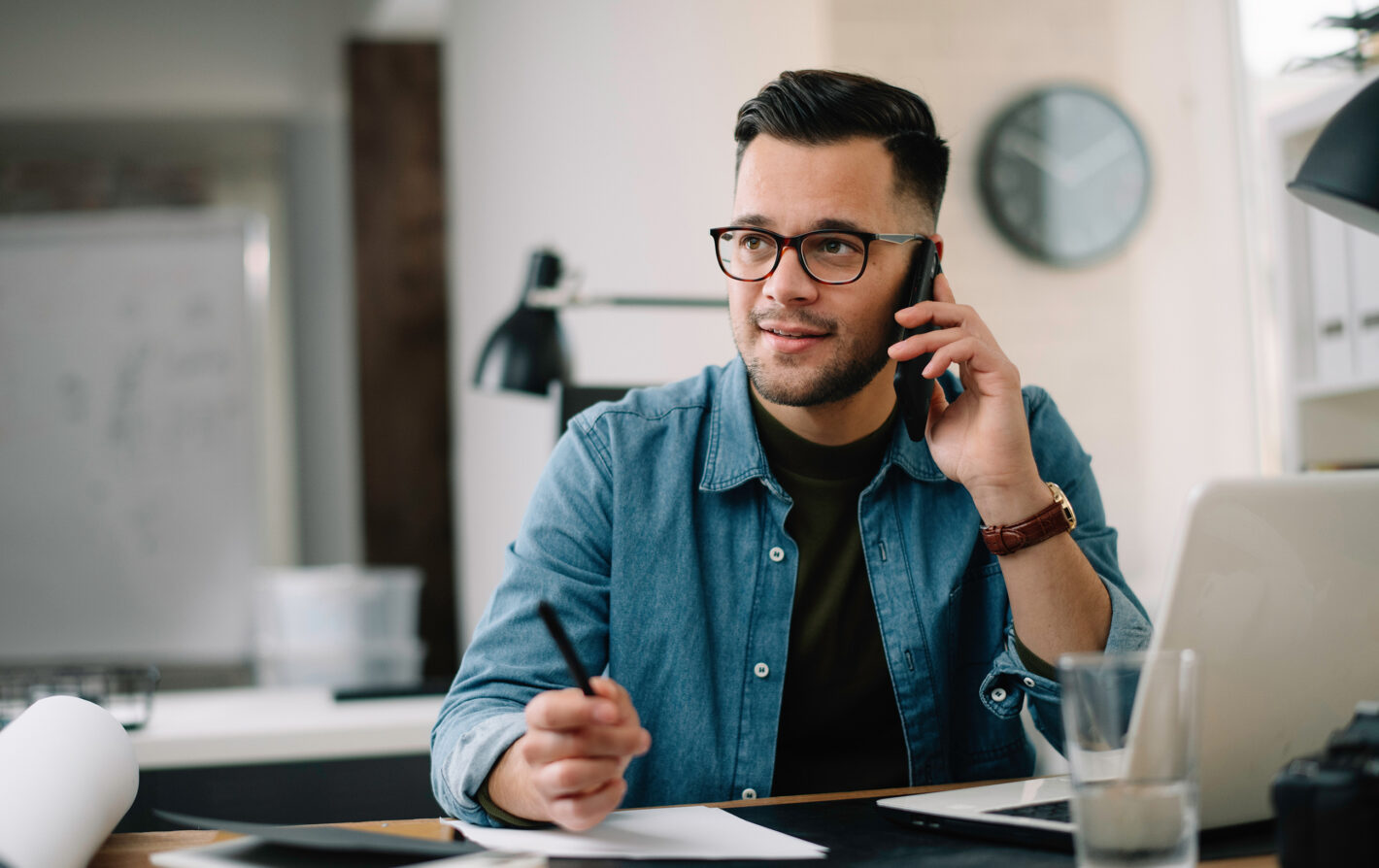 Man on the phone at his home office asking a question