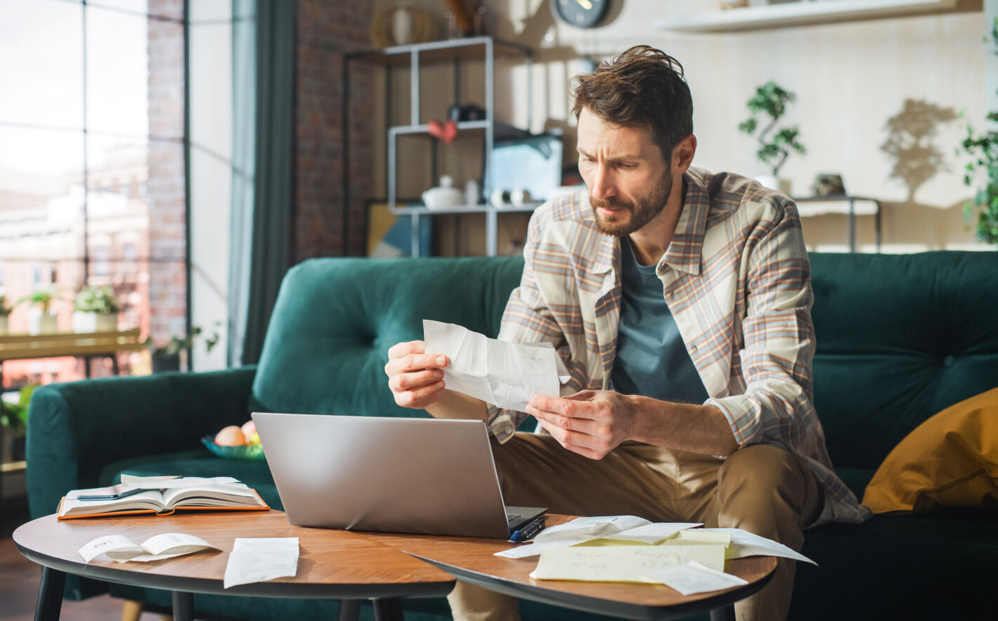 Streessed Man Using Laptop Computer Filling Tax Forms and Scared of Bankruptcy
